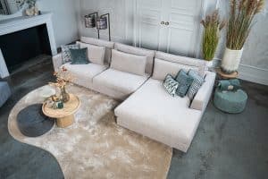 Hoekbank Claire in een lichte stof. Interieurstyling met hippe beige en petrol woonaccessoires.