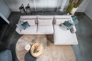 Hoekbank Claire in een lichte stof. Interieurstyling met hippe beige en petrol woonaccessoires.