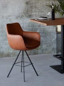 Sgabello da bar Max-X (66 cm) in pelle marrone su un tavolo da bar in legno