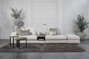 Lichte modulaire elementenbank Eva met innerbench en zachte kussens, gestyled met accessoires in een modern interieur.