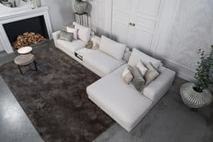 Lichte modulaire elementenbank Eva met innerbench en zachte kussens, gestyled met accessoires in een modern interieur.
