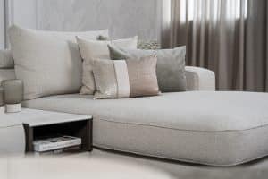 Lichte modulaire elementenbank Eva met innerbench en zachte kussens, gestyled met accessoires in een modern interieur.